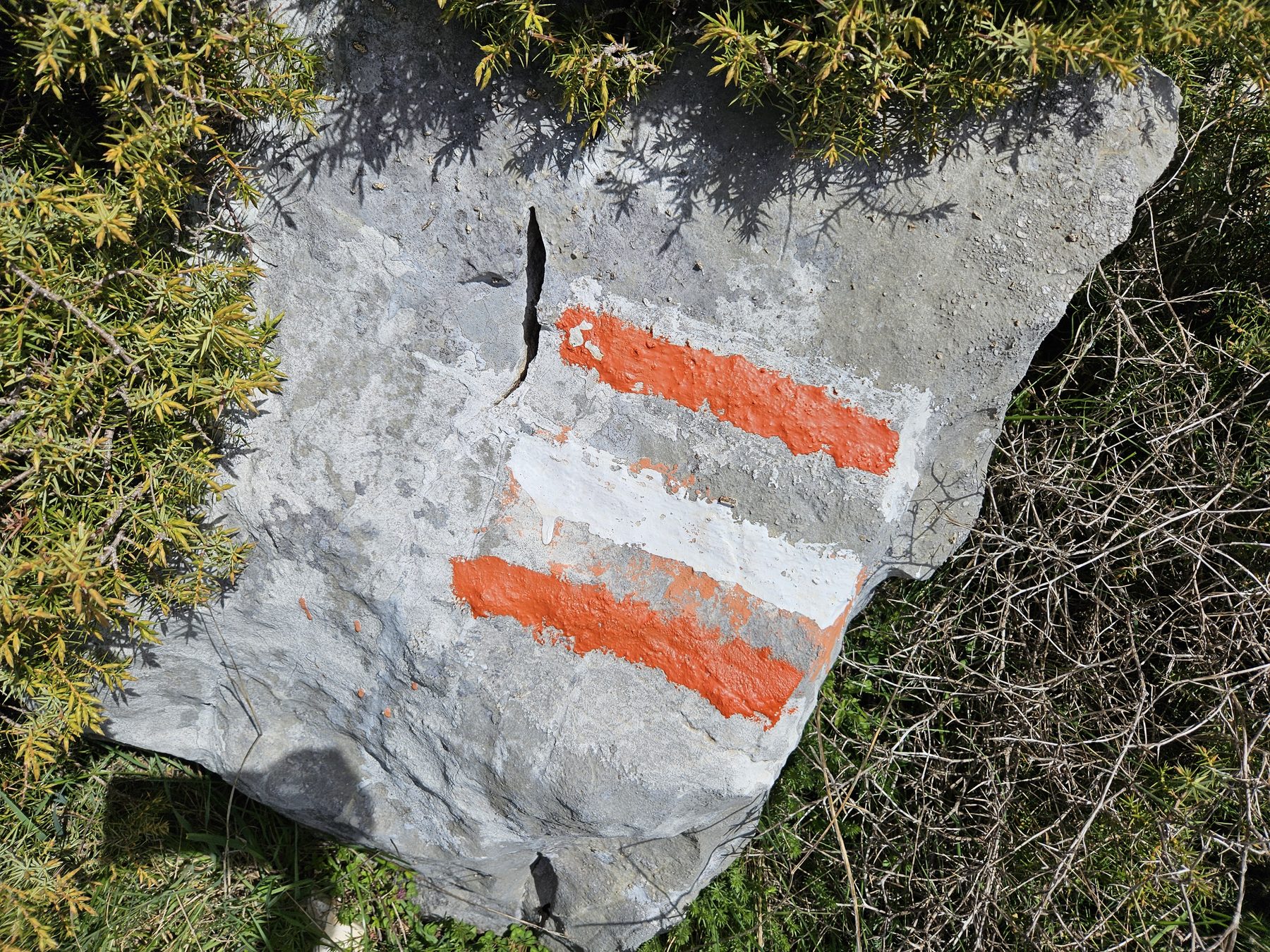 Red-and-white waymarks on the rock