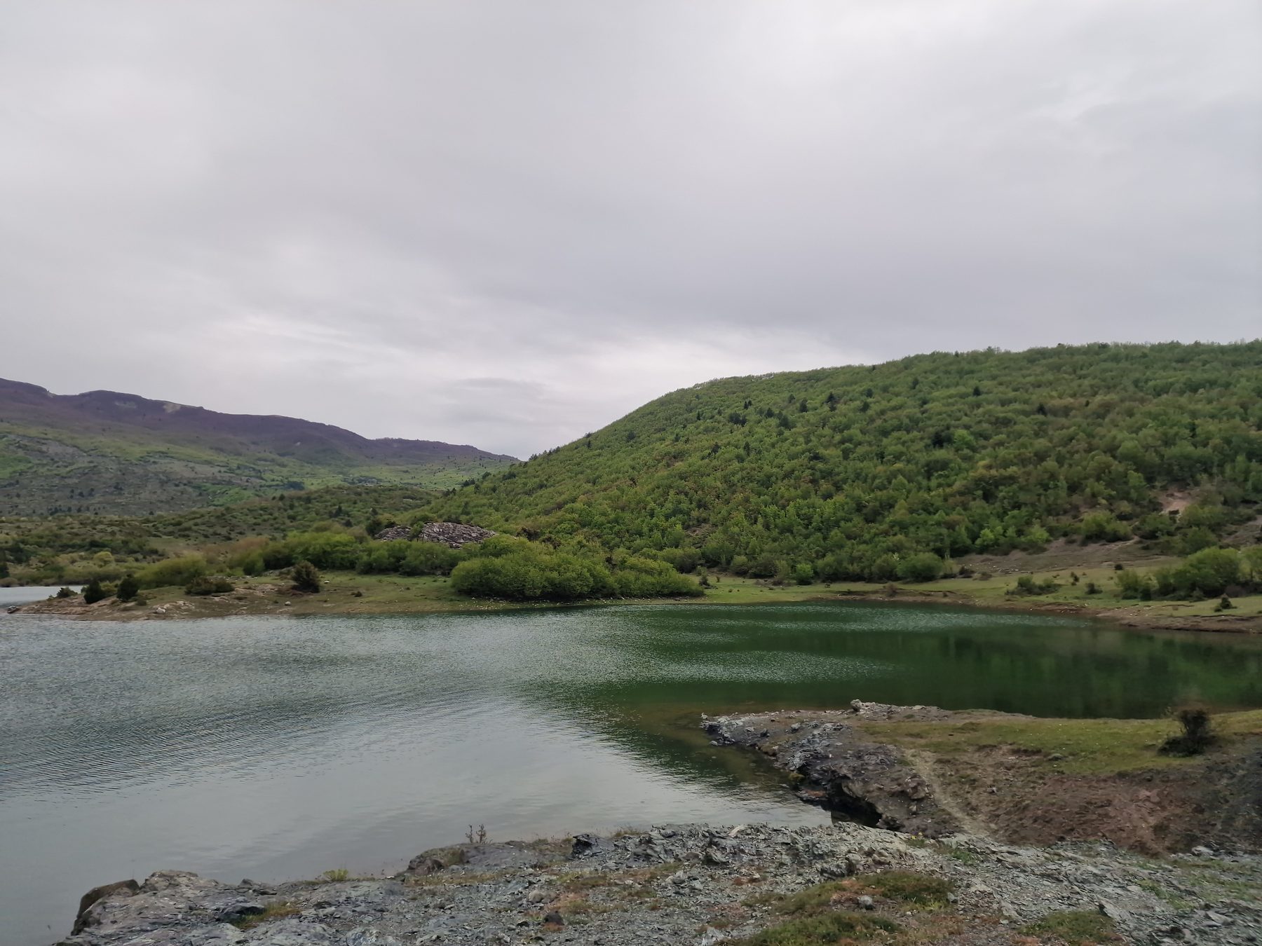 A lake among green hills
